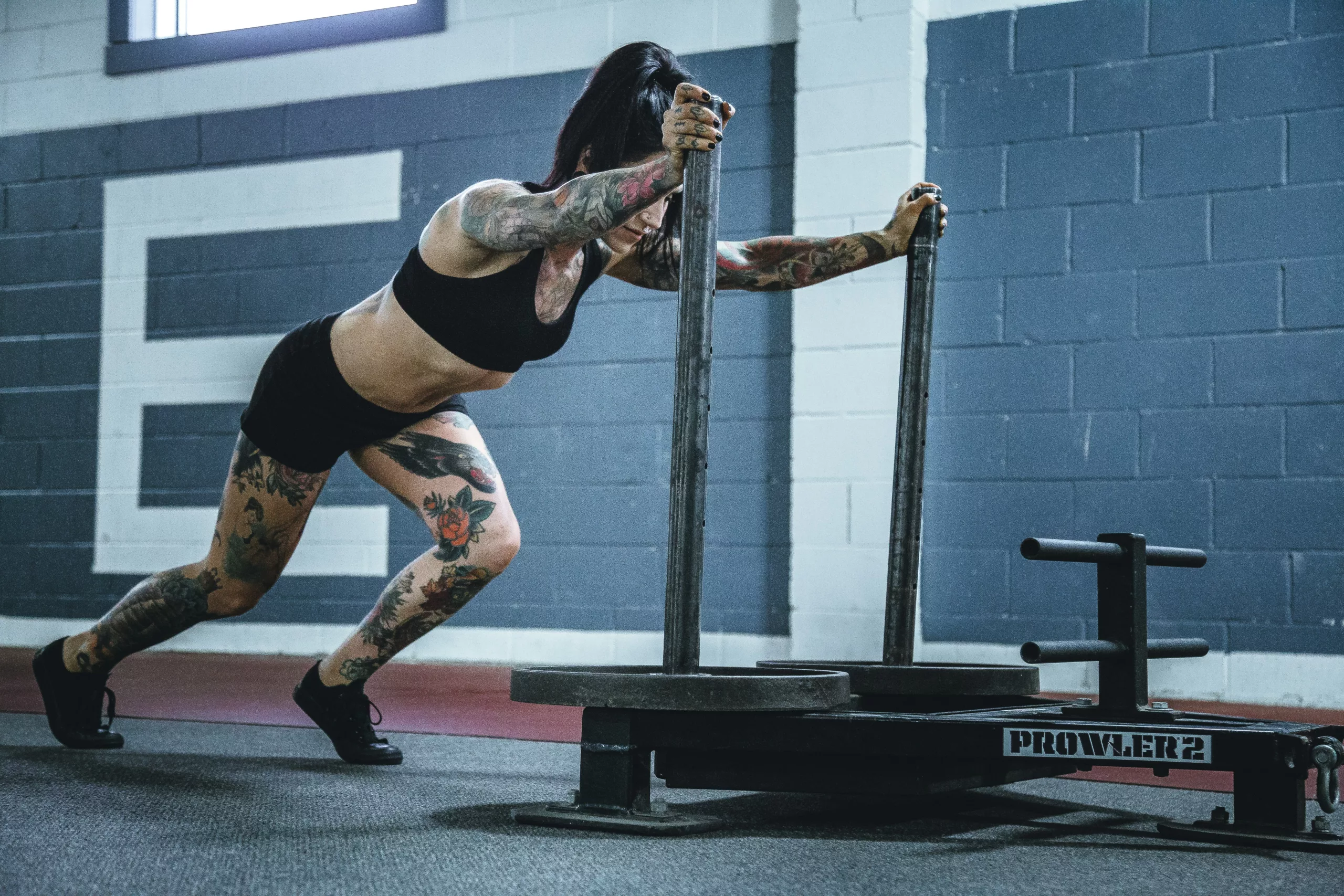 Woman pushing weights across floor